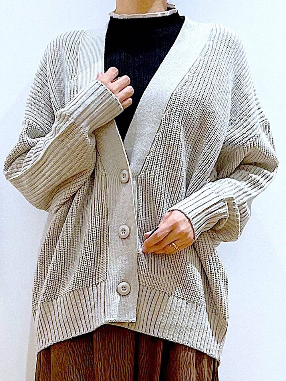 グレー系のカーディガン/ボレロ、ブラック系のニット/セーター、ブラウン系のショルダーバッグを着用したレディースの冬コーディネートの7枚目の写真