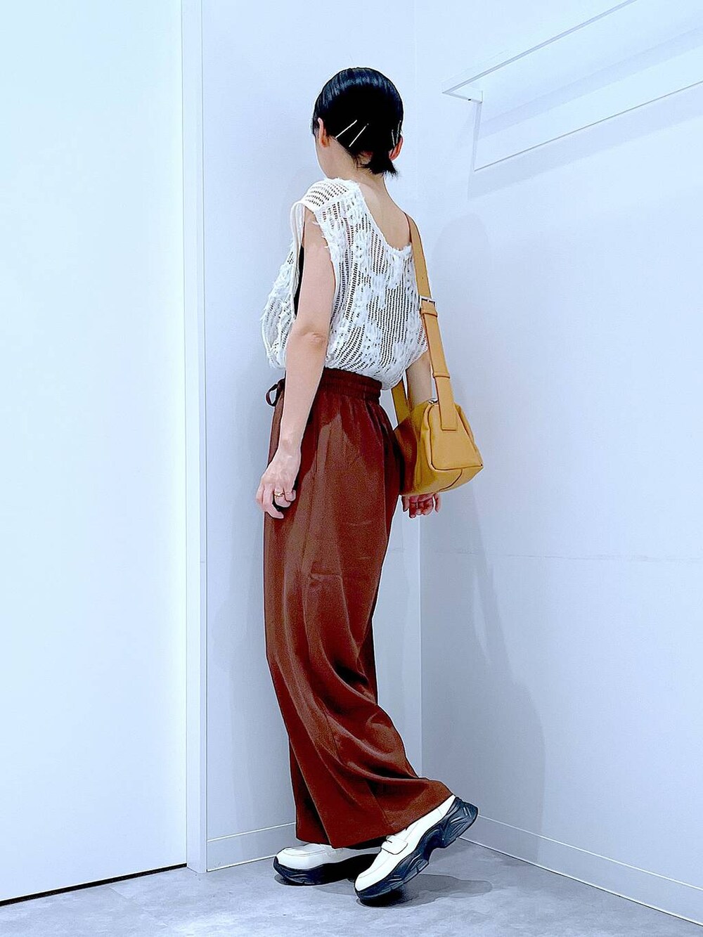 ベージュ系のショルダーバッグ、ホワイト系のローファー、ブラウン系のその他パンツを着用したレディースの秋コーディネートの3枚目の写真