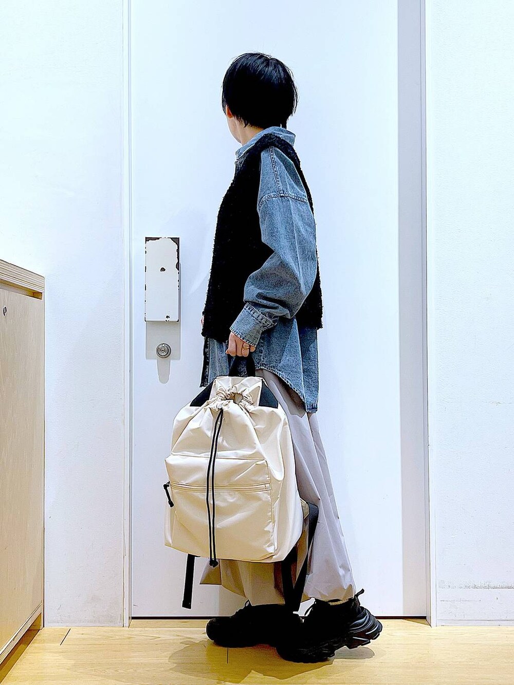 ブルー系のシャツ/ブラウス、ブラック系のスニーカー、ホワイト系のバックパック/リュックを着用したレディースの春コーディネートの3枚目の写真