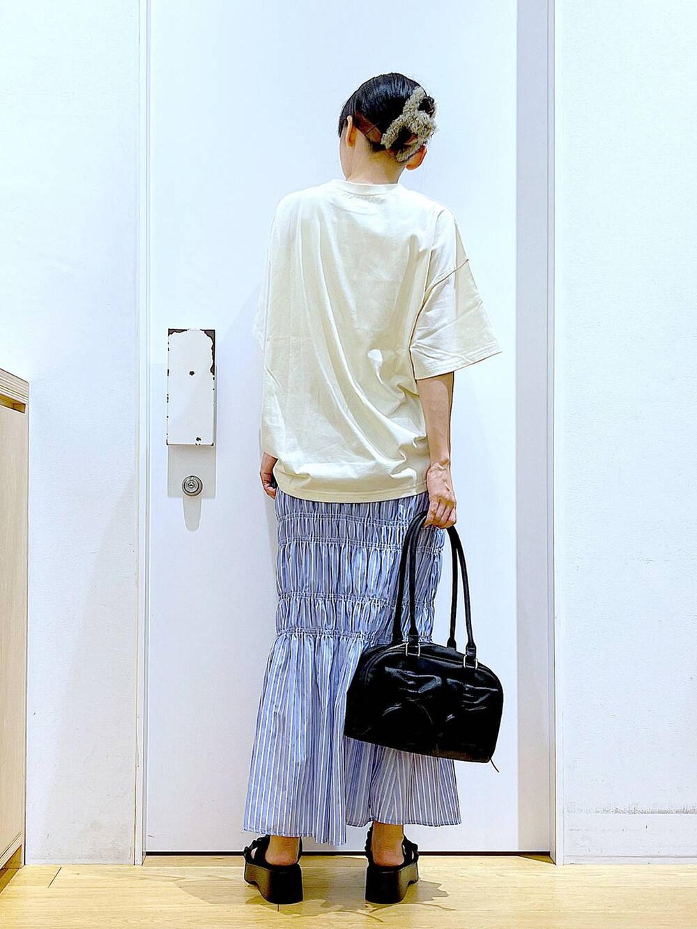 ブラック系のサンダル、その他のスカート、ブラック系のハンドバッグを着用したレディースの夏コーディネートの5枚目の写真