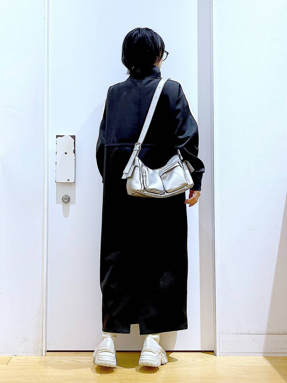 ベージュ系のブーツ、ブラック系のワンピース、その他のショルダーバッグを着用したレディースの秋コーディネートの5枚目の写真