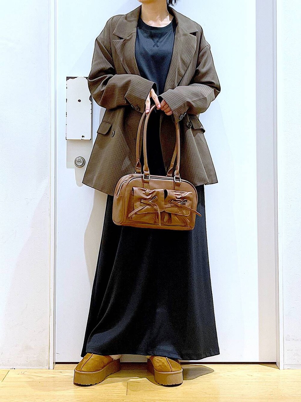 ベージュ系のスリッポン、ブラウン系のハンドバッグ、ブラウン系のテーラードジャケットを着用したレディースの秋コーディネートの6枚目の写真