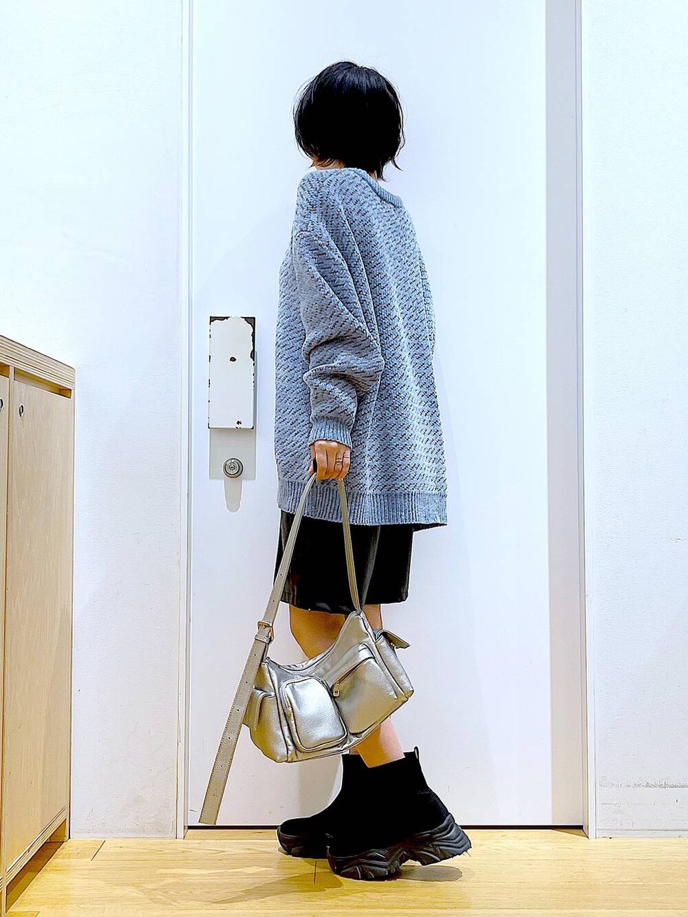 ブルー系のニット/セーター、ブラック系のブーツ、その他のショルダーバッグを着用したレディースの冬コーディネートの3枚目の写真