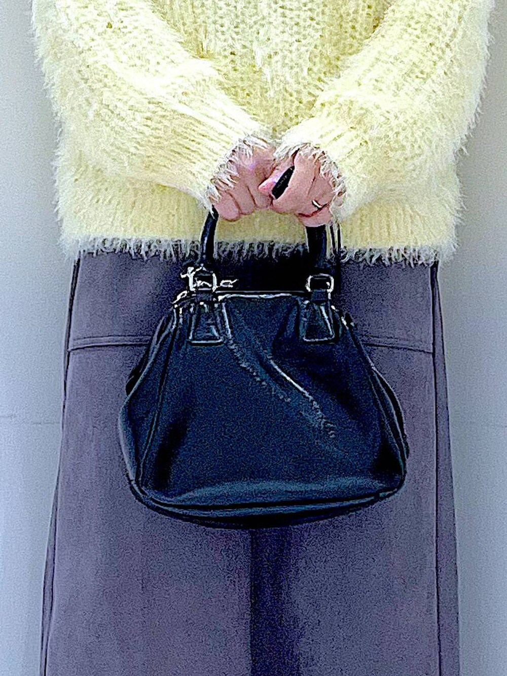 ブラック系のブーツ、イエロー系のニット/セーター、ブラック系のショルダーバッグを着用したレディースの冬コーディネートの9枚目の写真