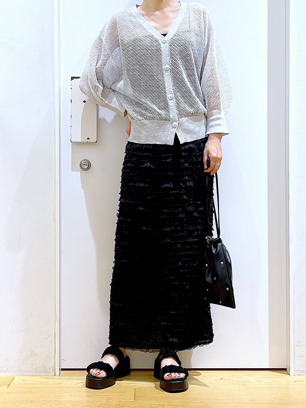 ブラック系のサンダル、ブラック系のショルダーバッグ、グレー系のカーディガン/ボレロを着用したレディースの夏コーディネートの6枚目の写真