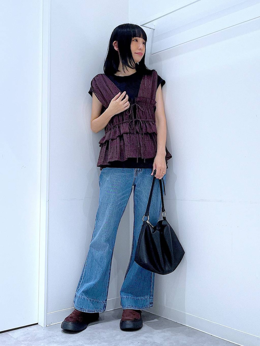 ブルー系のデニムパンツ、ブラウン系のベスト、ブラウン系のその他シューズを着用したレディースの夏コーディネートの2枚目の写真