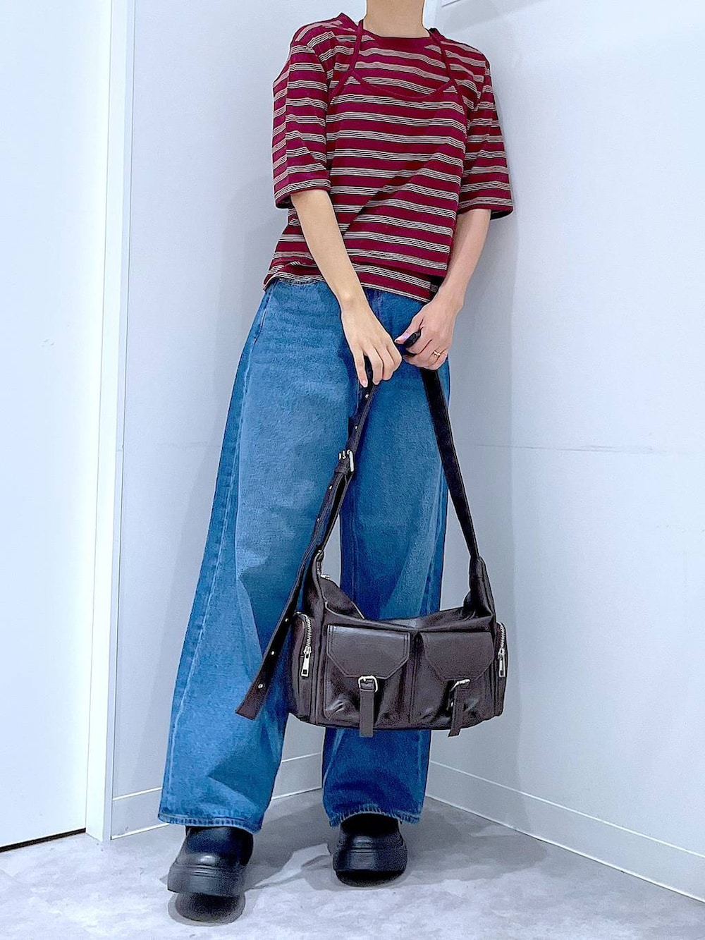 ブルー系のデニムパンツ、レッド系のTシャツ/カットソー、ブラック系のその他シューズを着用したレディースの秋コーディネートの6枚目の写真