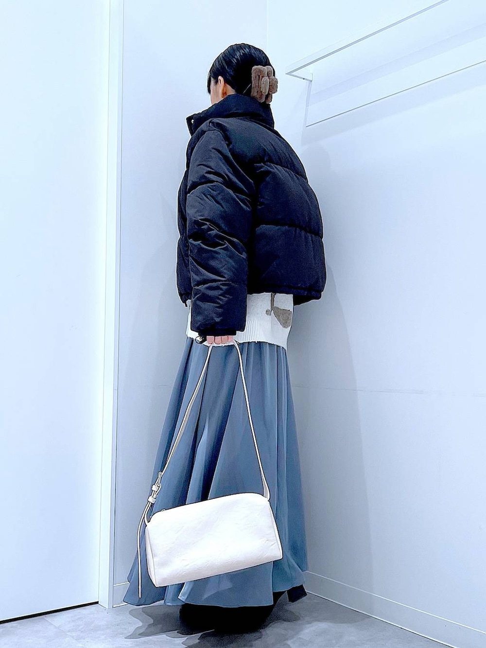 ブラック系のブルゾン、ブラック系のブーツ、ベージュ系のニット/セーターを着用したレディースの冬コーディネートの3枚目の写真