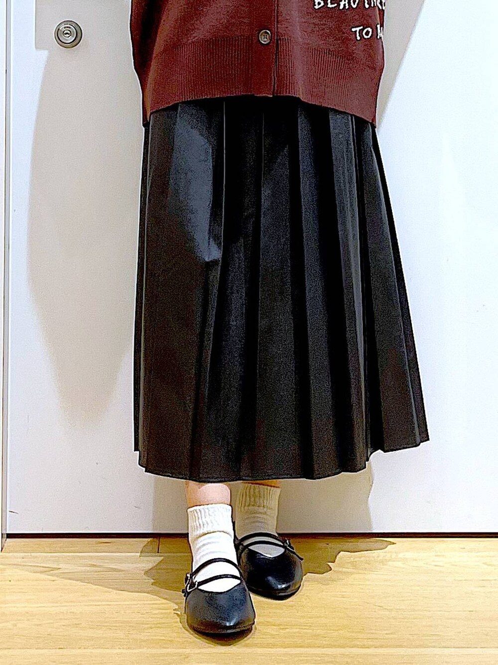 ブラック系のパンプス、ブラック系のスカート、ベージュ系のショルダーバッグを着用したレディースの秋コーディネートの8枚目の写真