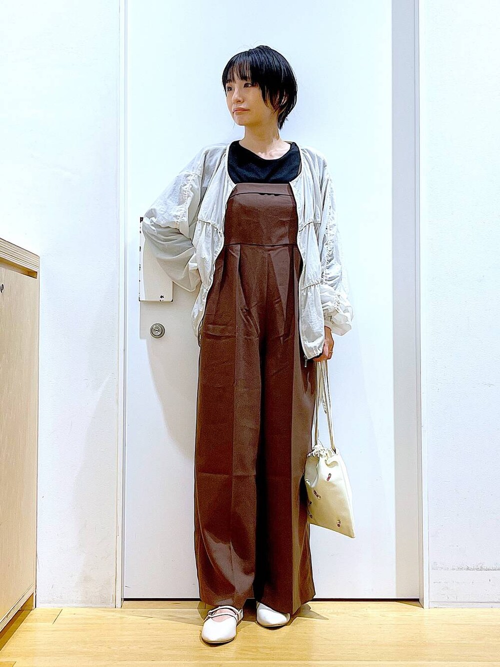 ホワイト系のショルダーバッグ、ホワイト系のパンプス、ブラック系のTシャツ/カットソーを着用したレディースの秋コーディネートの2枚目の写真