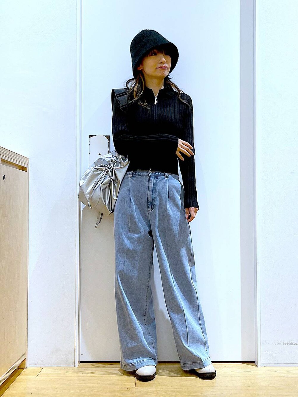 ブルー系のデニムパンツ、ブラック系のカーディガン/ボレロ、ベージュ系のブーツを着用したレディースの冬コーディネートの2枚目の写真