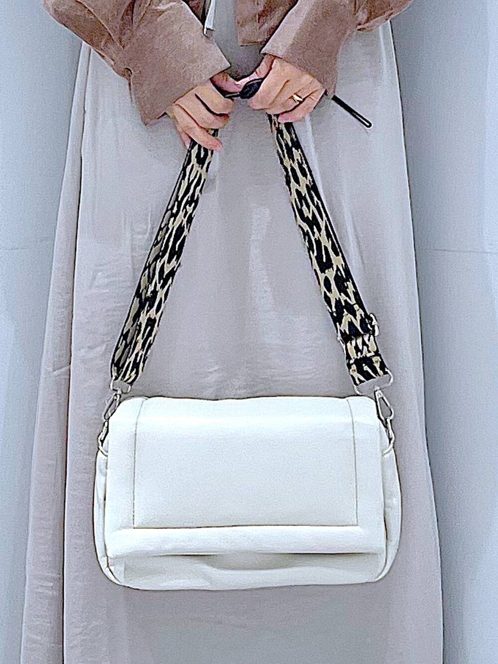 ベージュ系のスカート、ホワイト系のショルダーバッグ、ブラック系のブーツを着用したレディースの秋コーディネートの9枚目の写真