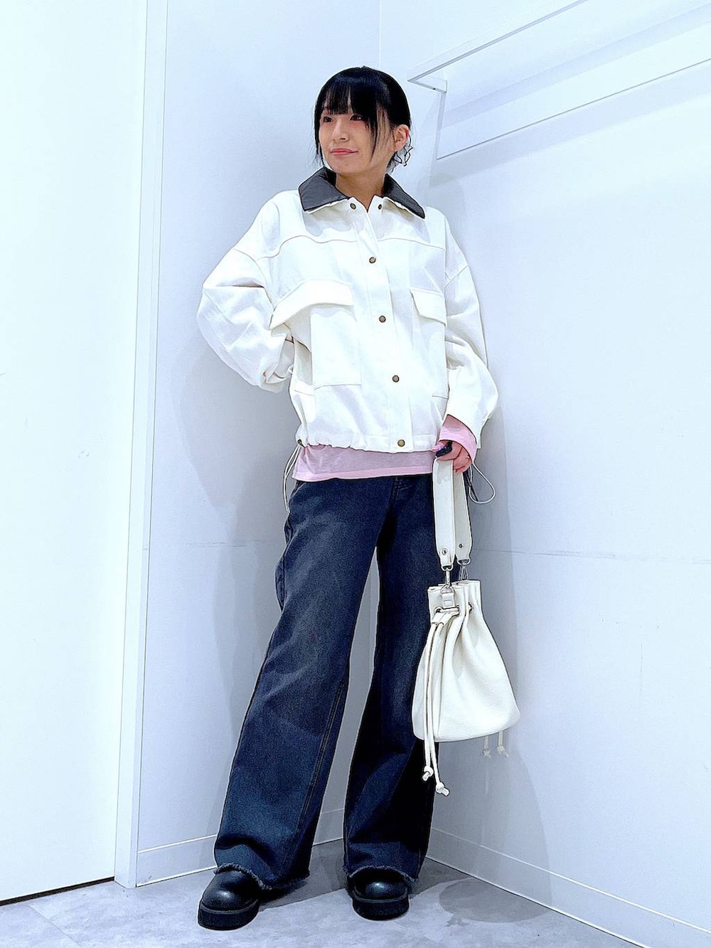 ピンク系のTシャツ/カットソー、ブラック系のデニムパンツ、ホワイト系のショルダーバッグを着用したレディースの春コーディネートの2枚目の写真