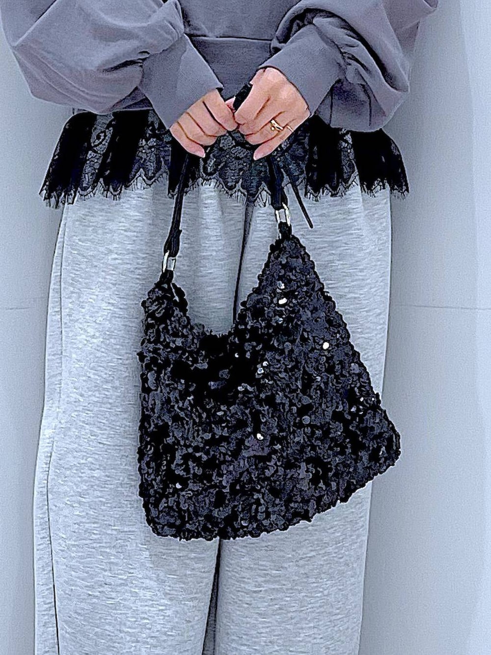 グレー系のスウェット、ブラック系のショルダーバッグ、ブラック系のタンクトップを着用したレディースの春コーディネートの9枚目の写真