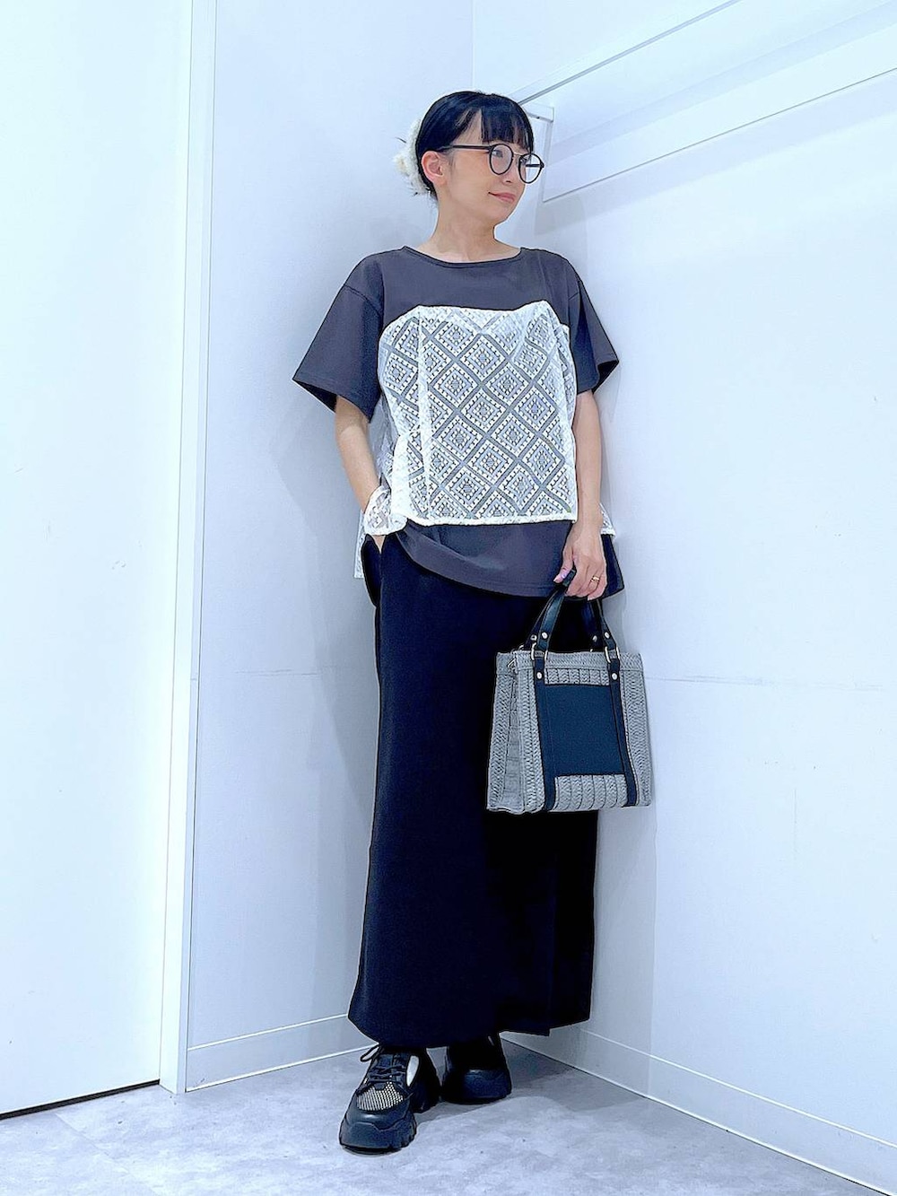 グレー系のショルダーバッグ、ブラック系のスニーカー、グレー系のTシャツ/カットソーを着用したレディースの夏コーディネートの2枚目の写真