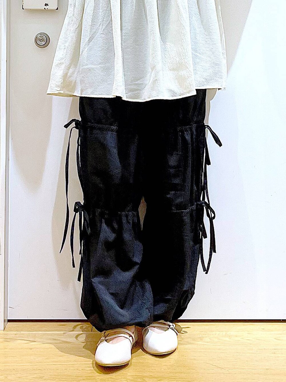 ホワイト系のパンプス、ブラック系のその他パンツ、ホワイト系のチュニックを着用したレディースの秋コーディネートの8枚目の写真