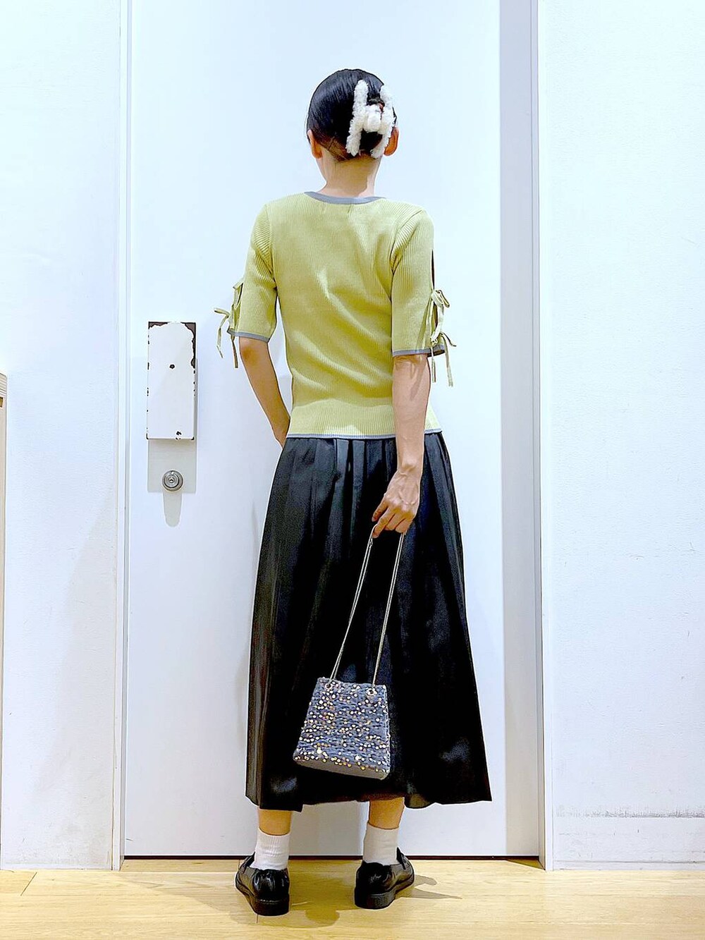 グレー系のショルダーバッグ、ブラック系のローファー、イエロー系のニット/セーターを着用したレディースの秋コーディネートの5枚目の写真