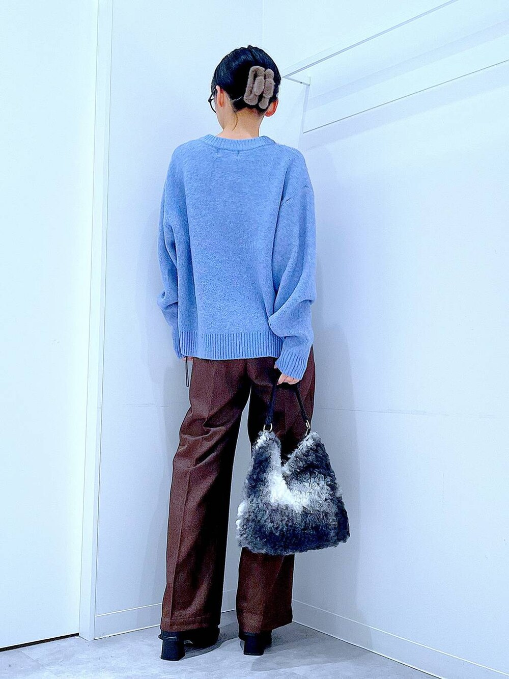 ブラック系のブーツ、ブラウン系のスラックス、ブラック系のショルダーバッグを着用したレディースの冬コーディネートの5枚目の写真