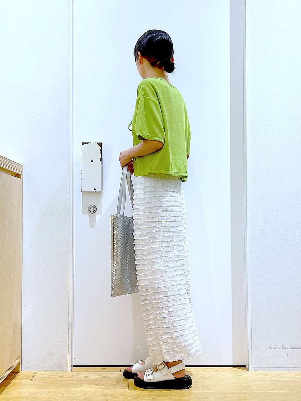 ホワイト系のサンダル、シルバー系のトートバッグ、ホワイト系のスカートを着用したレディースの秋コーディネートの3枚目の写真