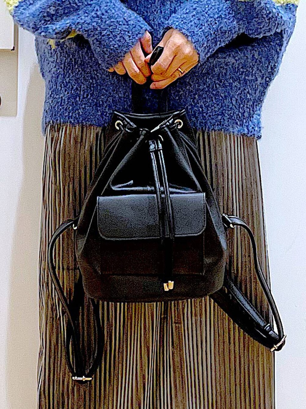 ブラック系のバックパック/リュック、グレー系のスカート、ブラック系のブーツを着用したレディースの冬コーディネートの9枚目の写真