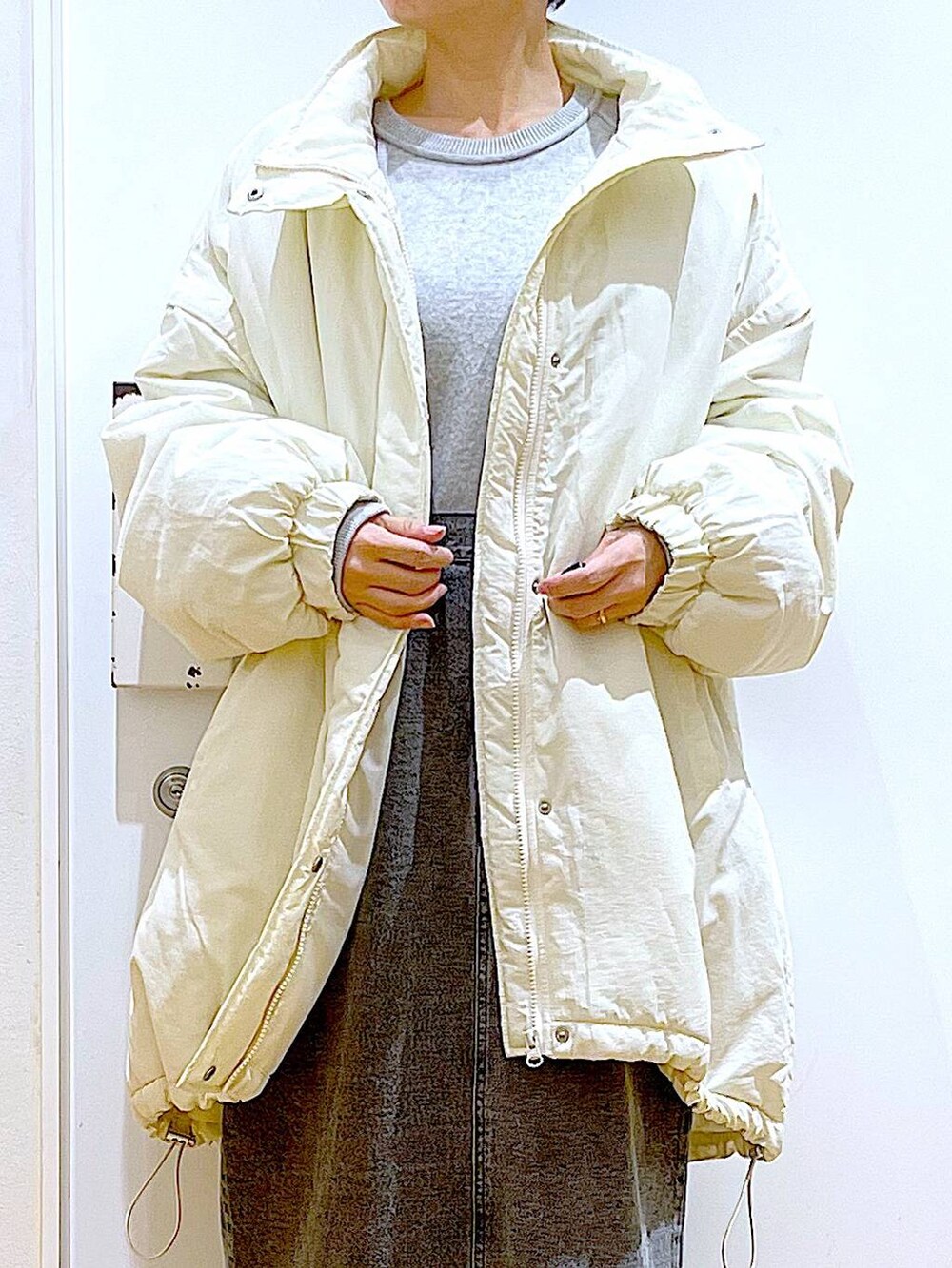 シルバー系のローファー、ホワイト系のその他アウター、ブラック系のショルダーバッグを着用したレディースの冬コーディネートの7枚目の写真