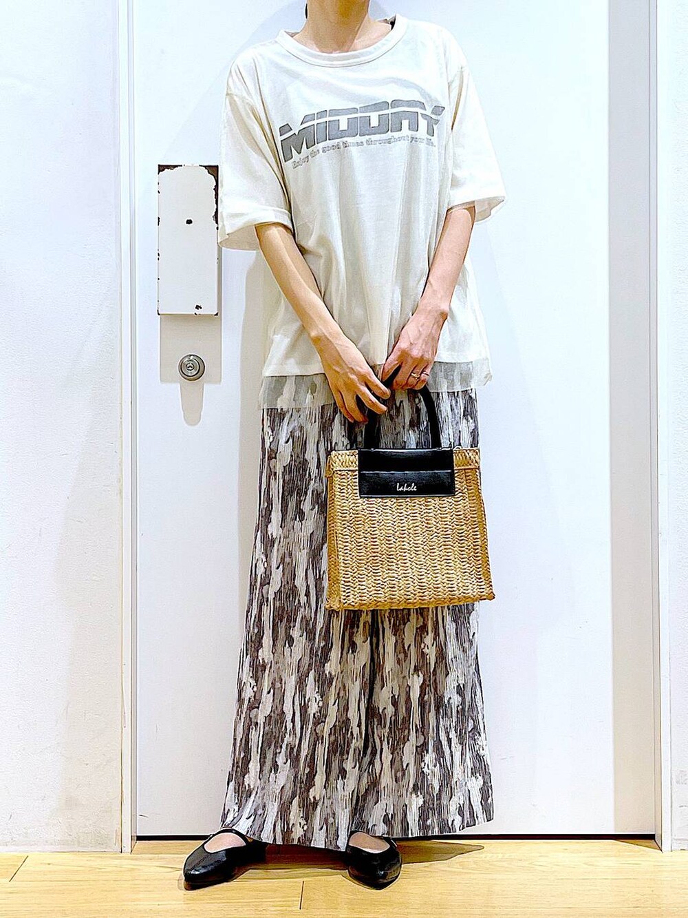 ホワイト系のTシャツ/カットソー、ブラック系のパンプス、ベージュ系のショルダーバッグを着用したレディースの夏コーディネートの6枚目の写真