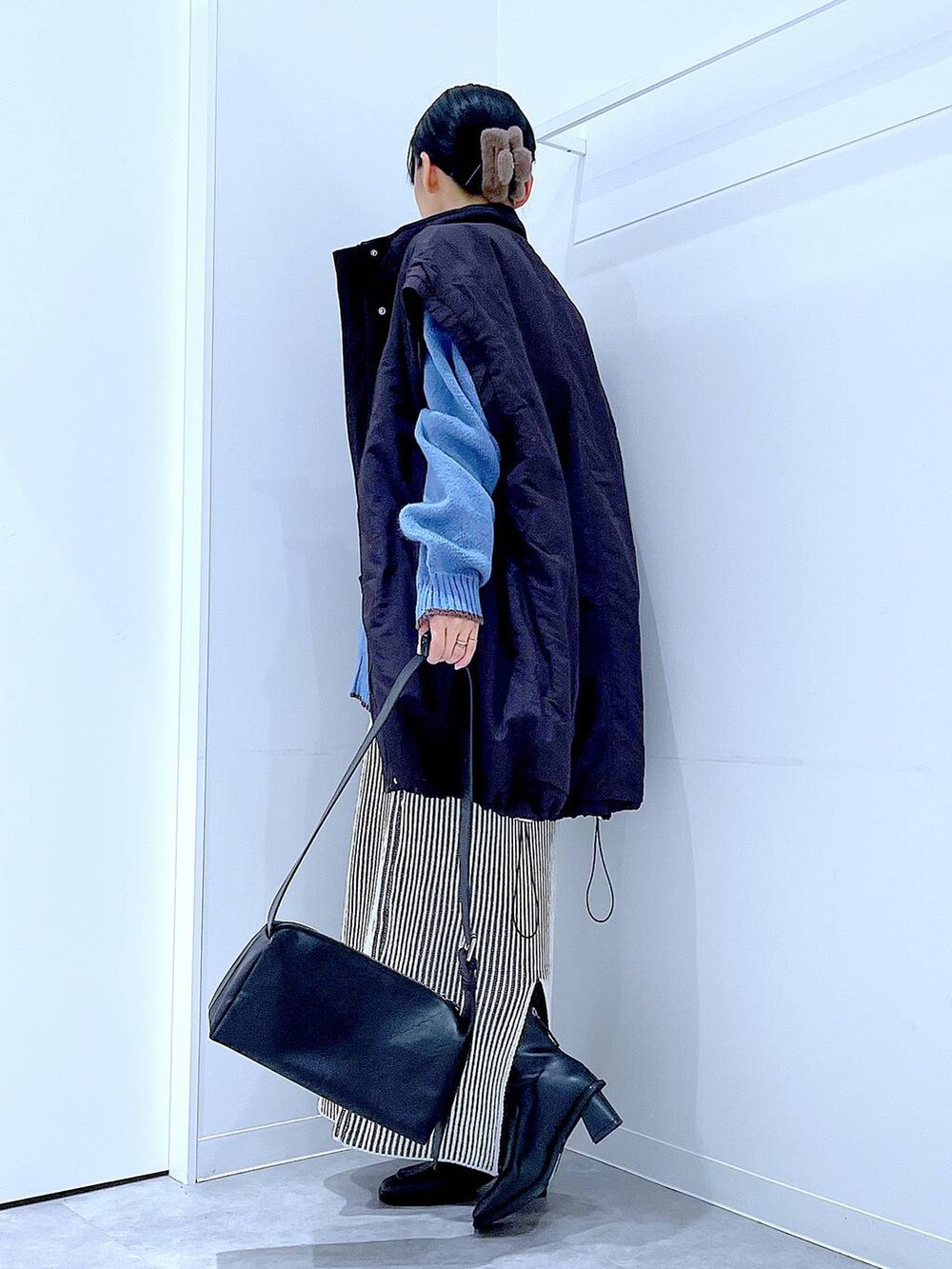 ブラック系のブルゾン、ベージュ系のスカート、ブラック系のブーツを着用したレディースの冬コーディネートの3枚目の写真