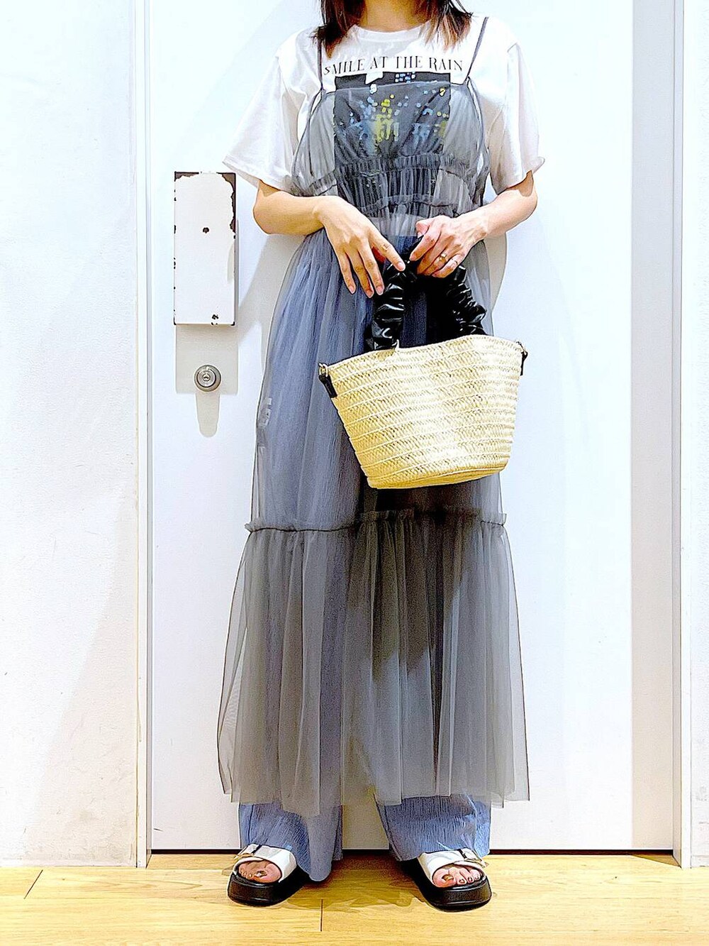 グレー系のワンピース、ホワイト系のショルダーバッグ、ホワイト系のサンダルを着用したレディースの夏コーディネートの6枚目の写真