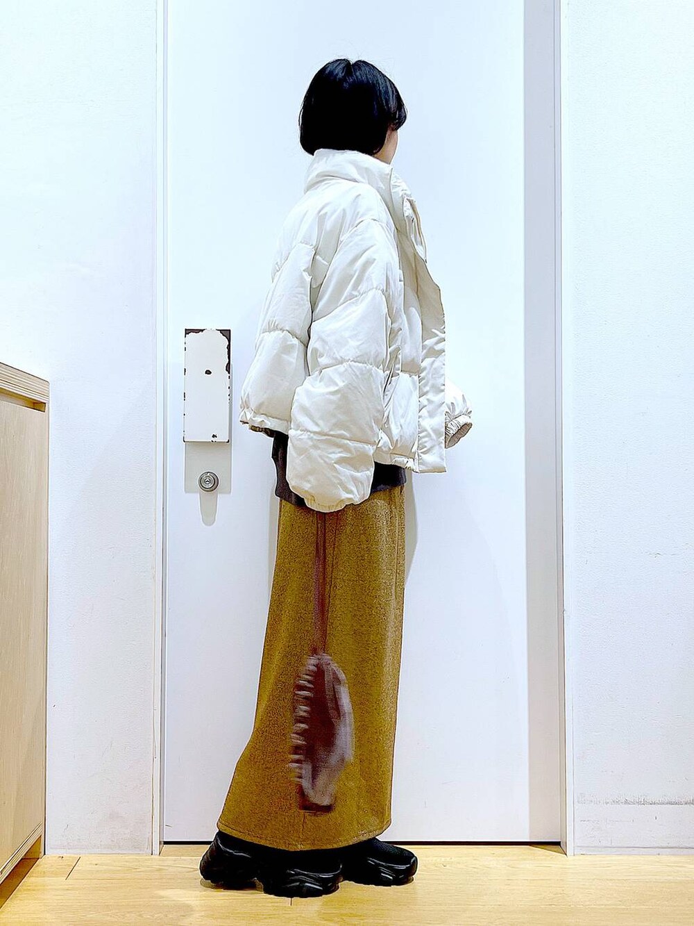 ベージュ系のブルゾン、ブラウン系のショルダーバッグ、ブラック系のブーツを着用したレディースの冬コーディネートの4枚目の写真