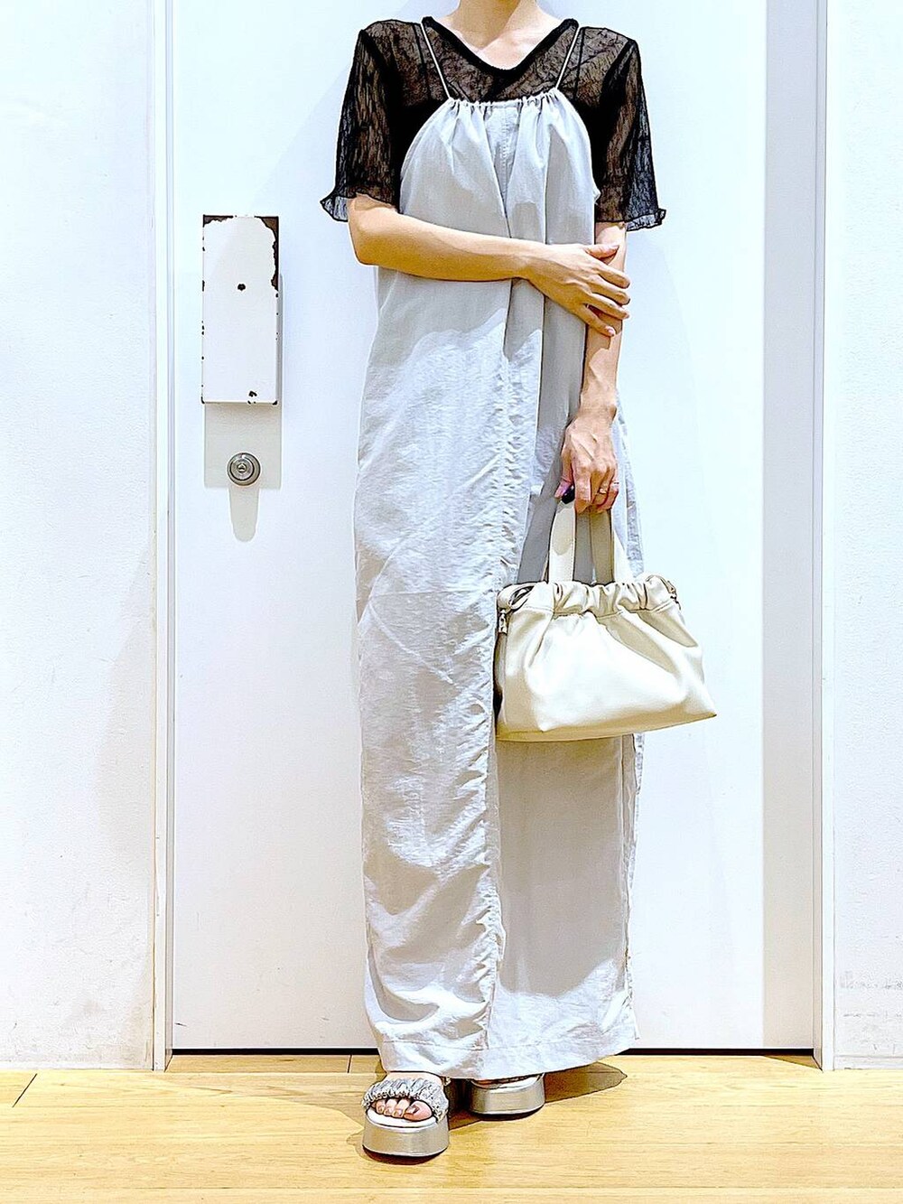 グレー系のワンピース、ホワイト系のショルダーバッグ、シルバー系のサンダルを着用したレディースの夏コーディネートの6枚目の写真