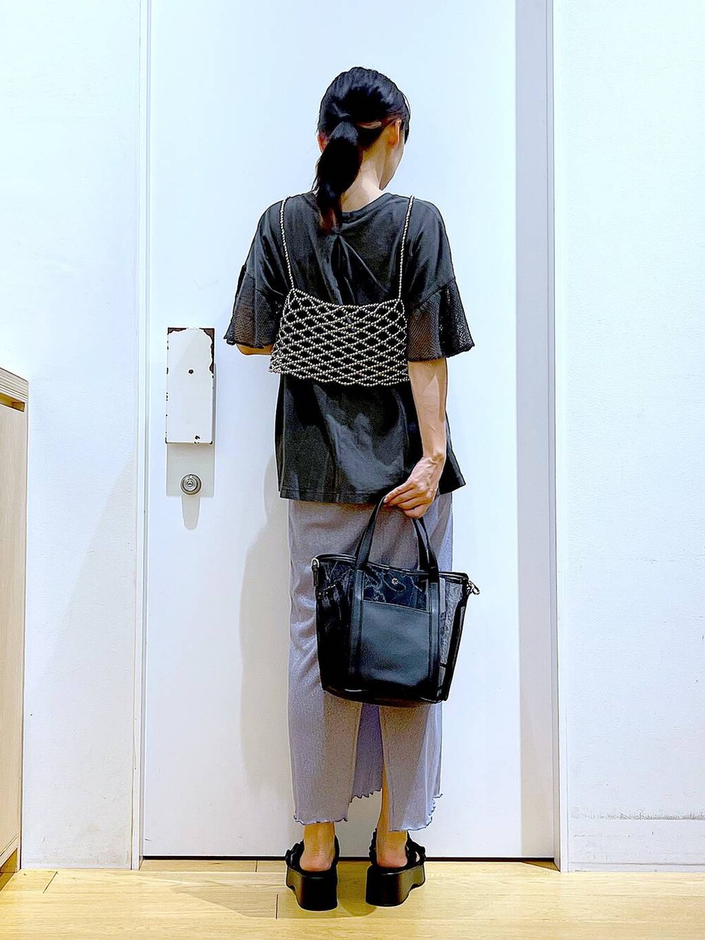 パープル系のスカート、ブラック系のサンダル、ブラック系のトートバッグを着用したレディースの夏コーディネートの5枚目の写真