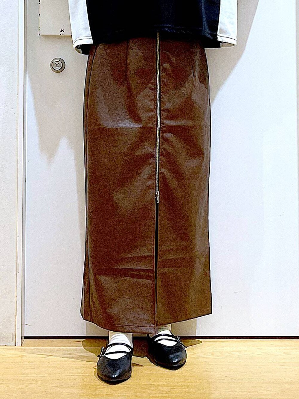 ブラウン系のスカート、ブラック系のパンプス、グレー系のショルダーバッグを着用したレディースの秋コーディネートの8枚目の写真