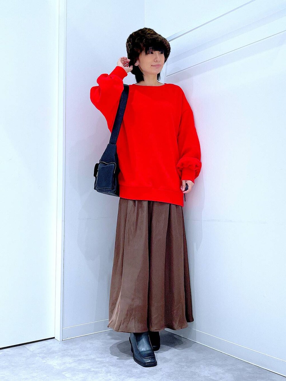 ブラック系のショルダーバッグ、ブラック系のブーツ、レッド系のスウェットを着用したレディースの秋コーディネートの2枚目の写真