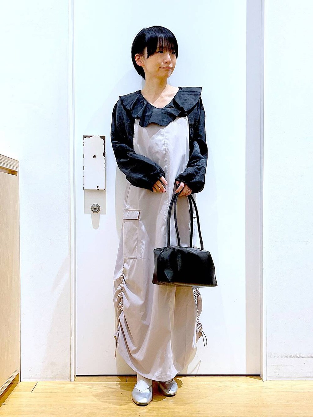 ブラック系のボストンバッグ、シルバー系のパンプス、グレー系のシャツ/ブラウスを着用したレディースの春コーディネートの2枚目の写真