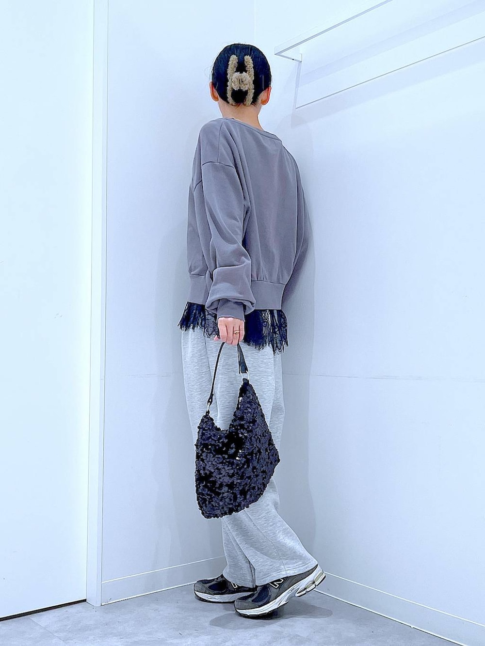 グレー系のスウェット、ブラック系のショルダーバッグ、ブラック系のタンクトップを着用したレディースの春コーディネートの3枚目の写真