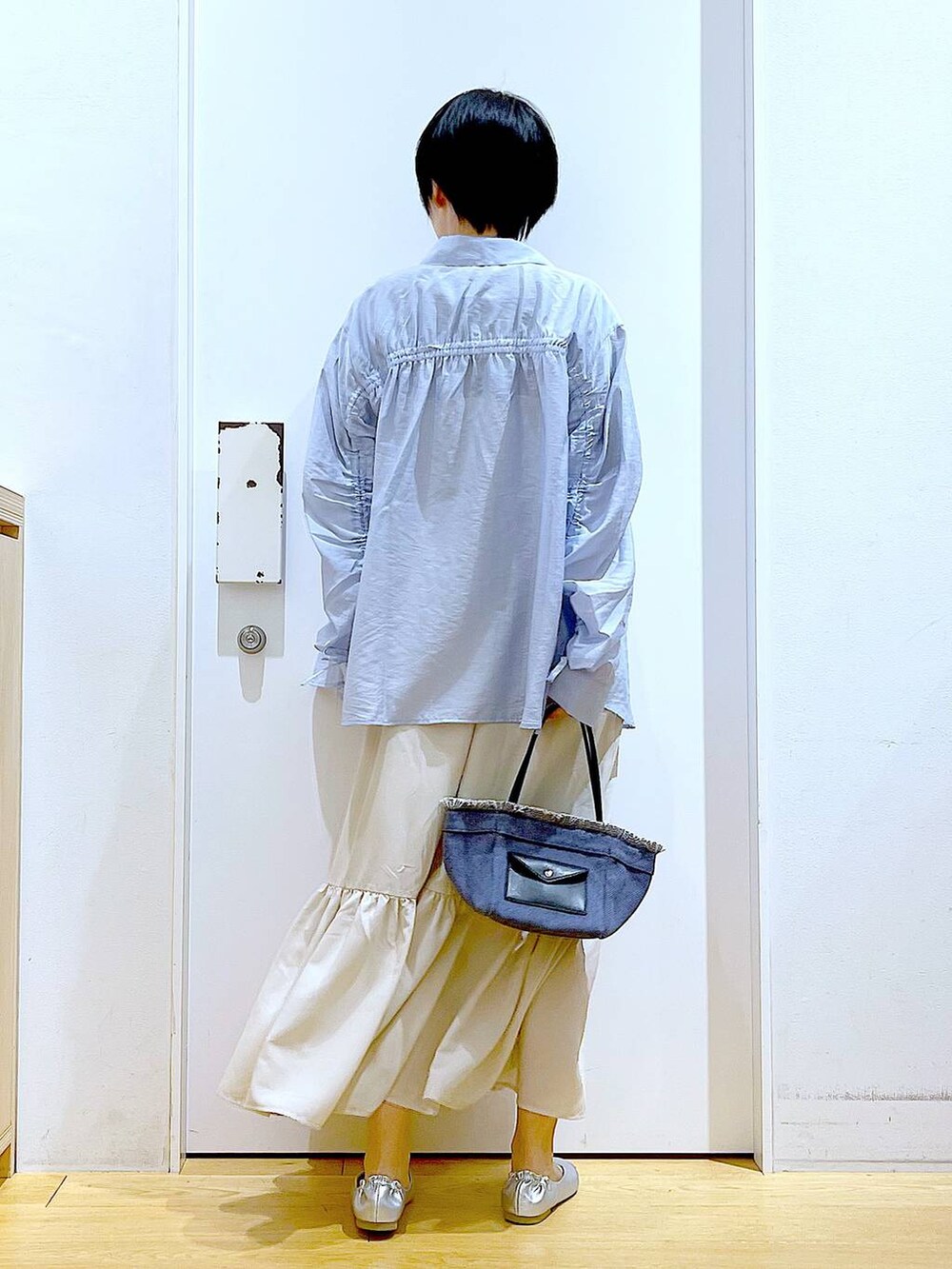 シルバー系のパンプス、ブルー系のショルダーバッグ、ブルー系のシャツ/ブラウスを着用したレディースの春コーディネートの5枚目の写真