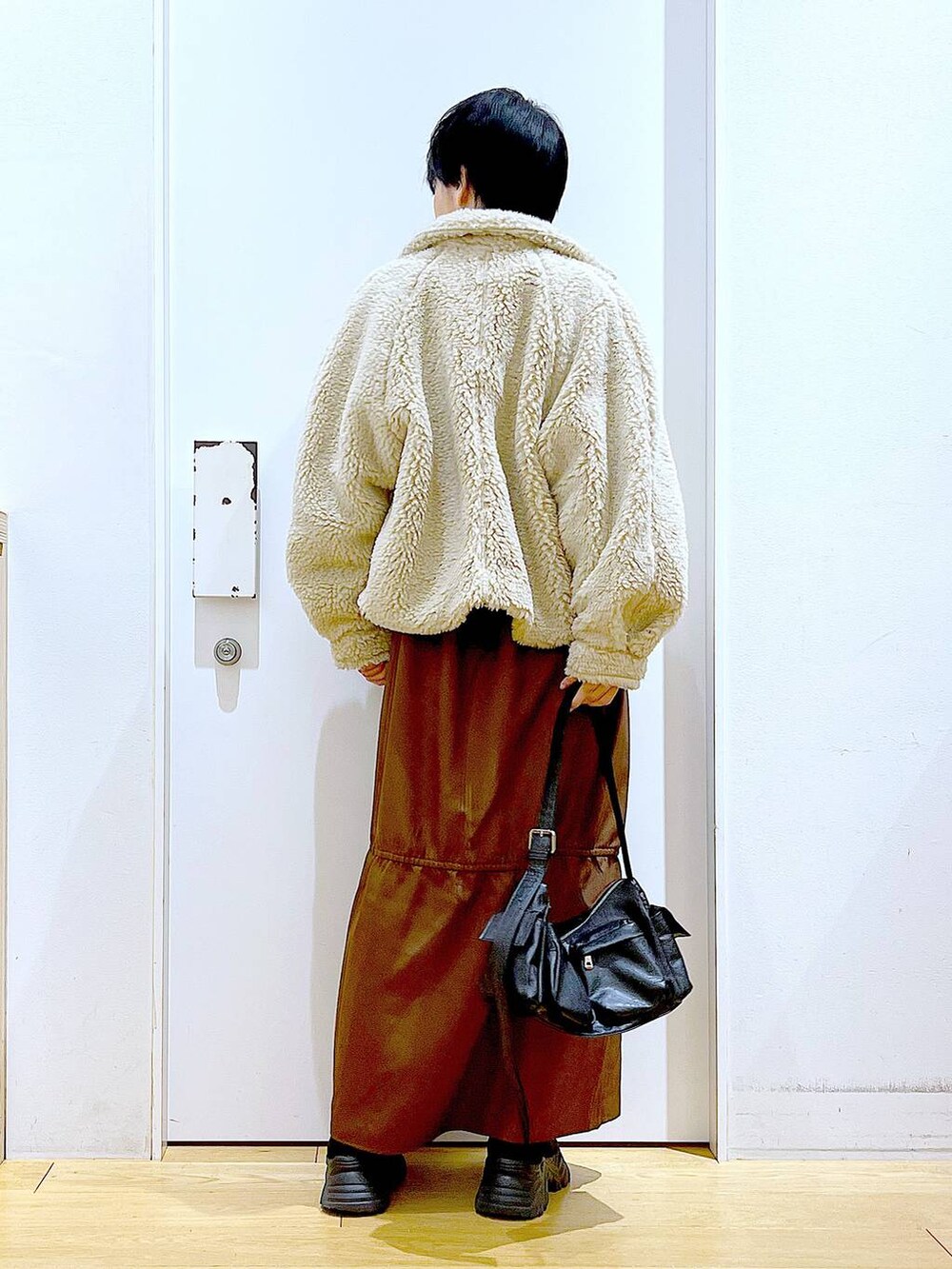 ホワイト系のブルゾン、ホワイト系のスウェット、ブラック系のブーツを着用したレディースの冬コーディネートの5枚目の写真