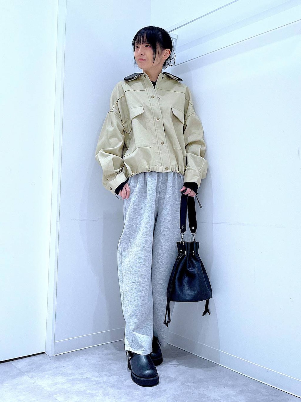 ブラック系のサンダル、ブラック系のショルダーバッグ、ベージュ系のブルゾンを着用したレディースの春コーディネートの2枚目の写真