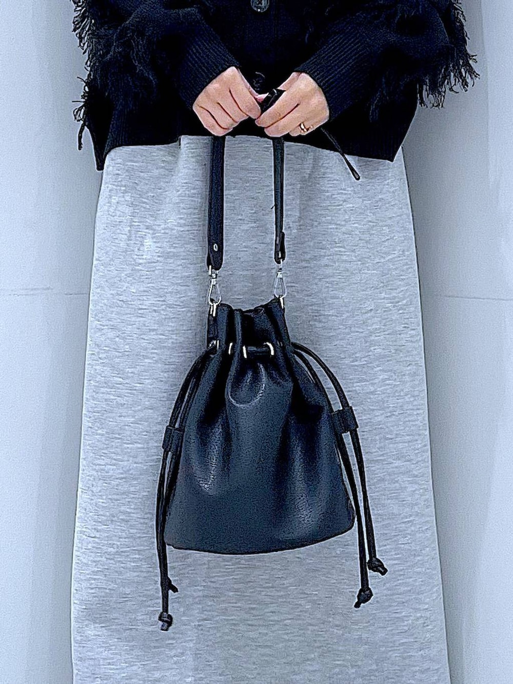 グレー系のスカート、ブラック系のショルダーバッグ、ブラック系のカーディガン/ボレロを着用したレディースの春コーディネートの9枚目の写真