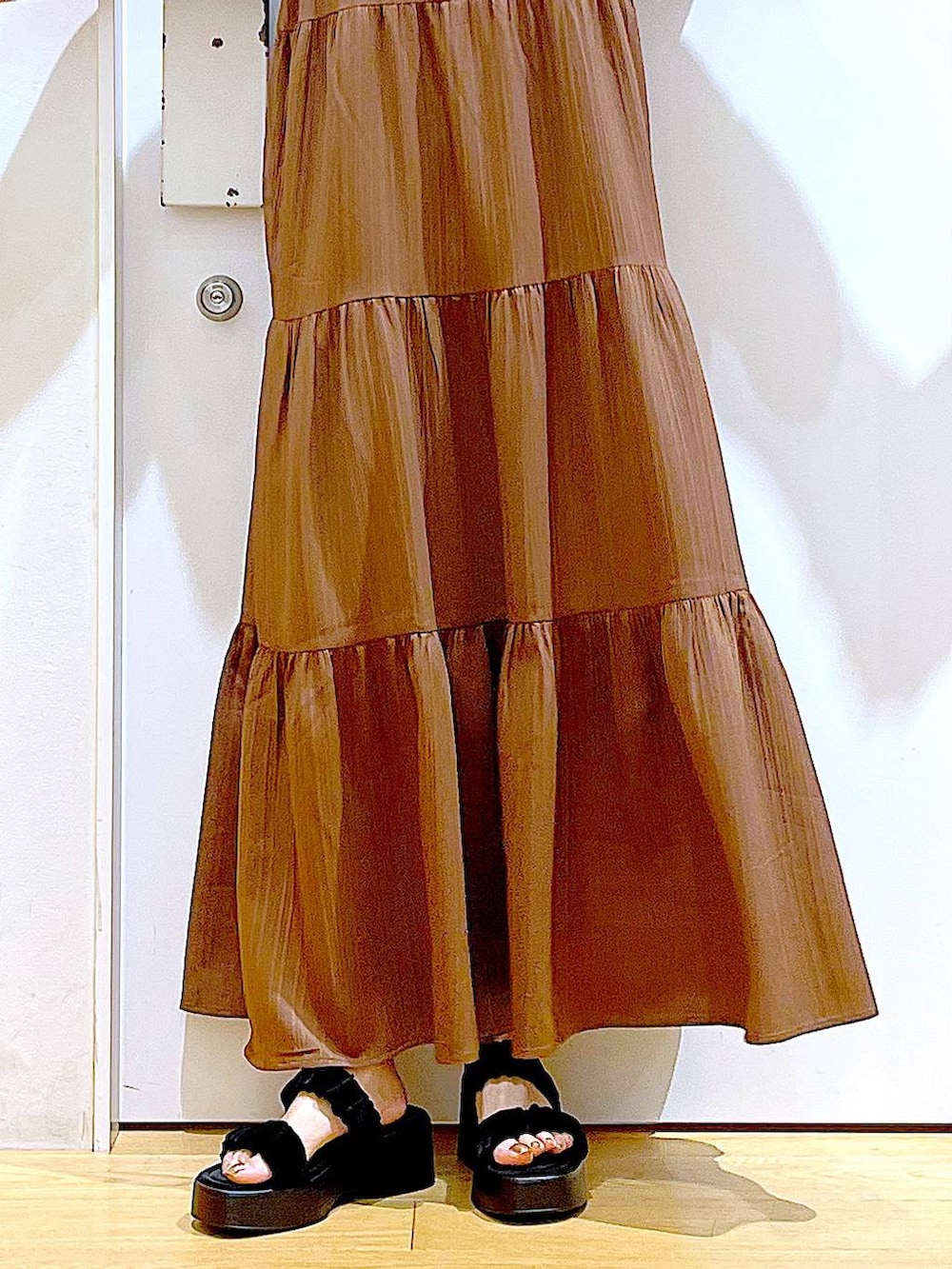 ブラウン系のショルダーバッグ、ブラック系のサンダル、グレー系のTシャツ/カットソーを着用したレディースの夏コーディネートの9枚目の写真