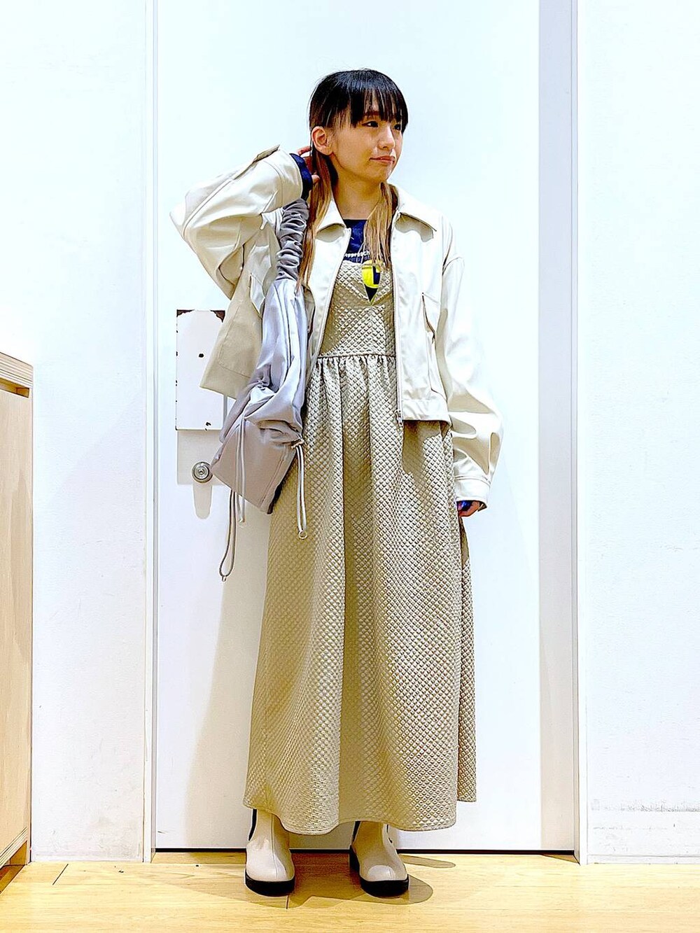 ベージュ系のブルゾン、ブラウン系のワンピース、ブルー系のTシャツ/カットソーを着用したレディースの春コーディネートの2枚目の写真