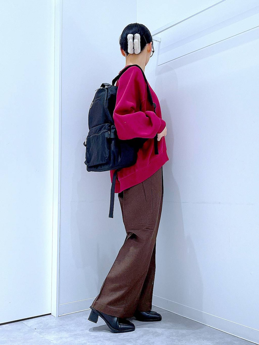 ブラック系のブーツ、ブラウン系のスラックス、ブラック系のバックパック/リュックを着用したレディースの冬コーディネートの4枚目の写真