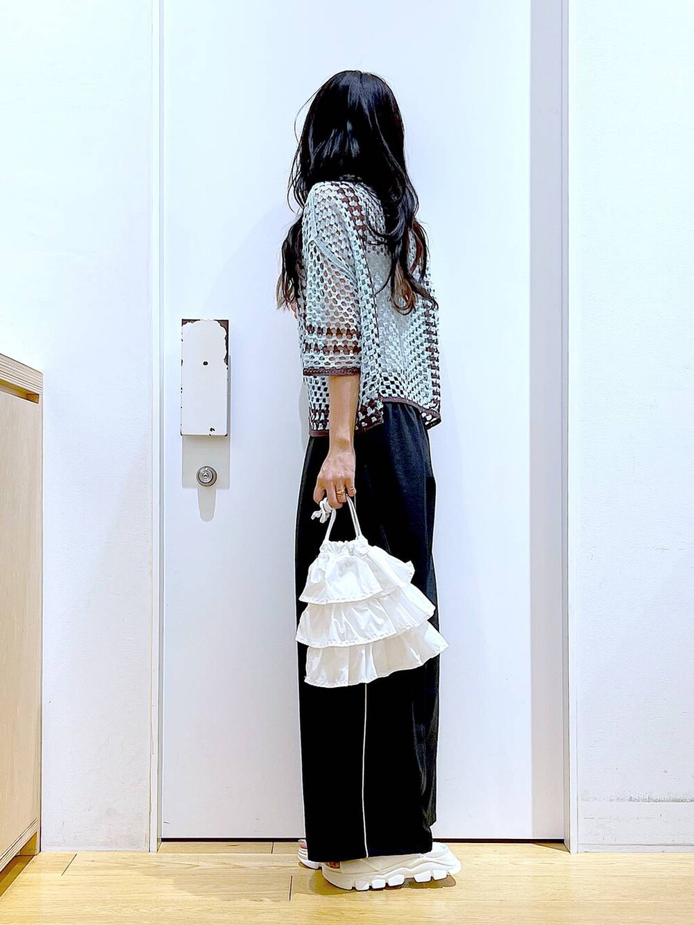 ホワイト系のショルダーバッグ、ホワイト系のサンダル、グリーン系のカーディガン/ボレロを着用したレディースの春コーディネートの3枚目の写真