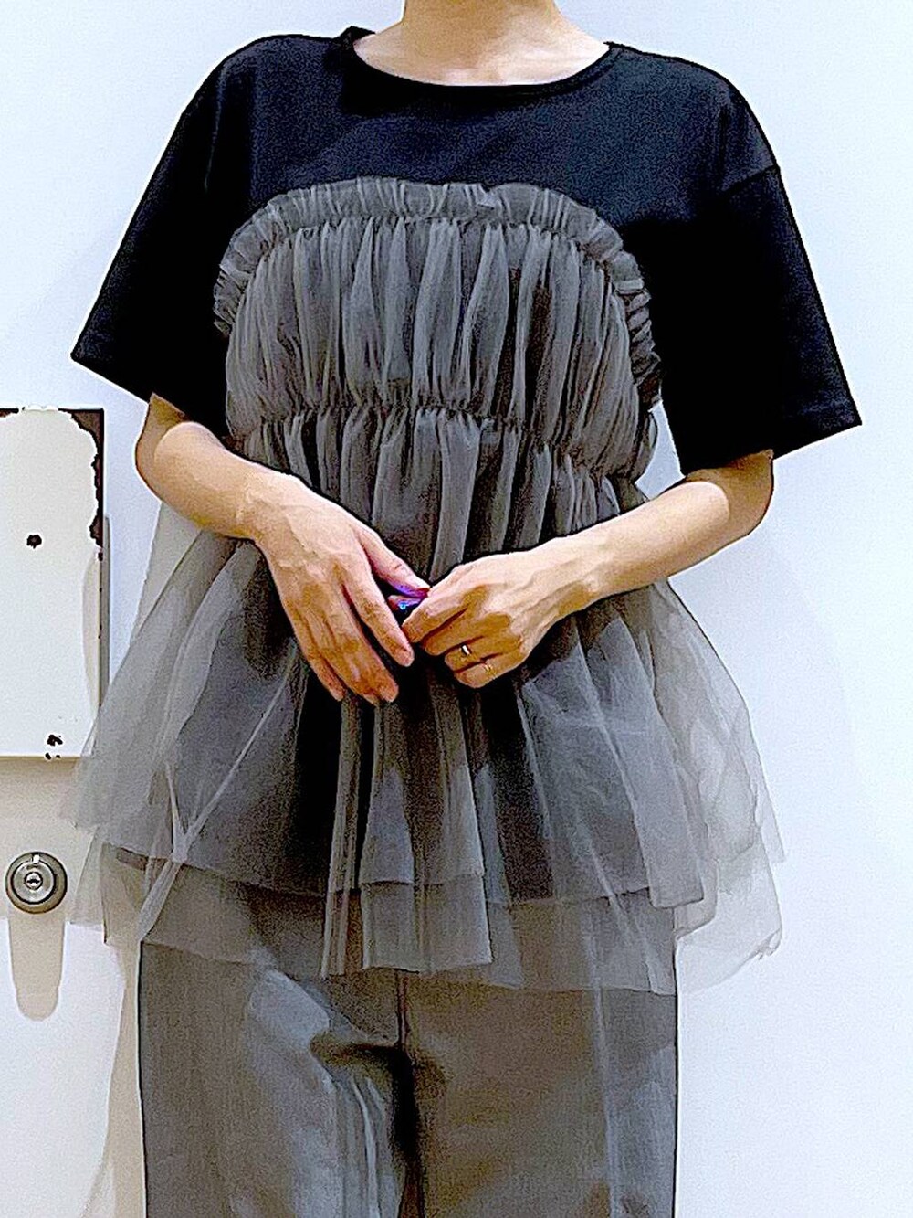 ブラック系のショルダーバッグ、ブラック系のサンダル、ブラック系のTシャツ/カットソーを着用したレディースの夏コーディネートの7枚目の写真