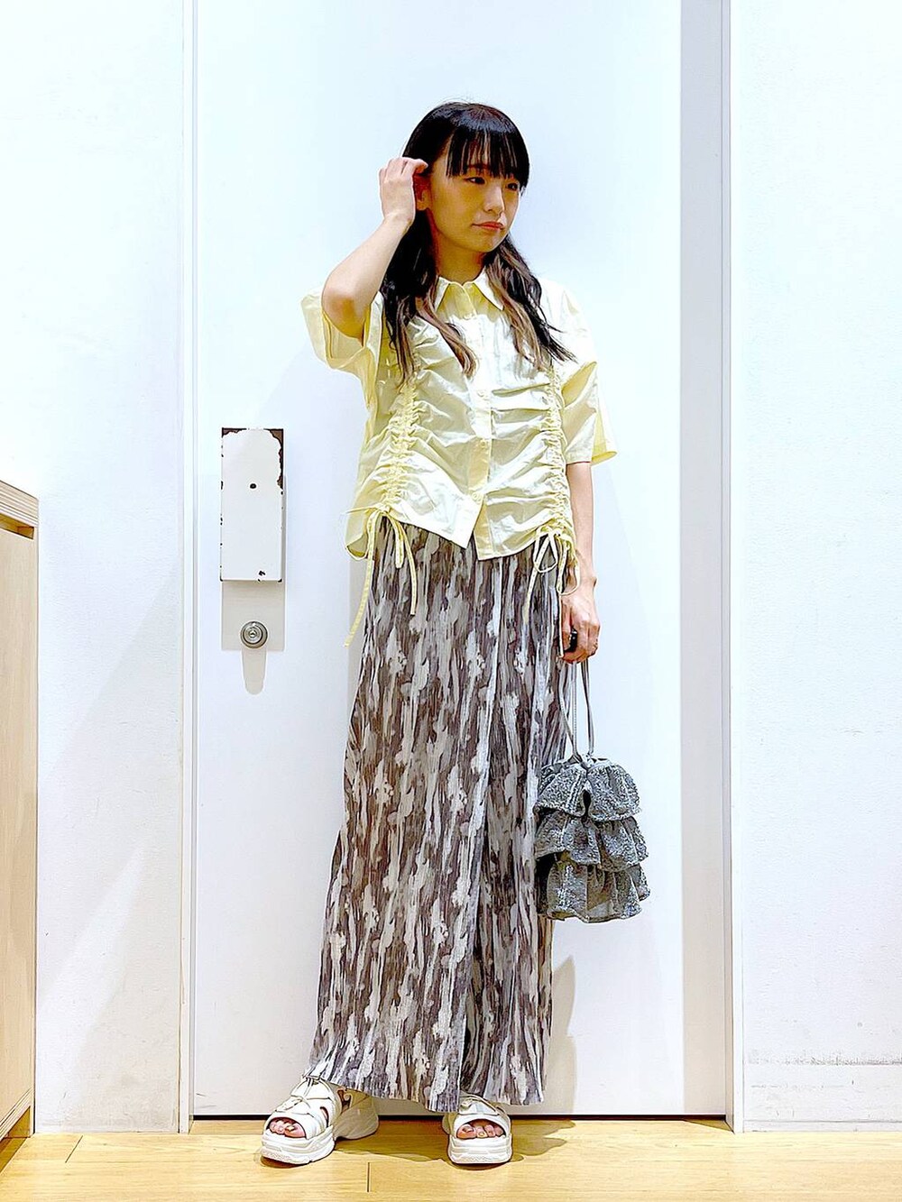 シルバー系のショルダーバッグ、ホワイト系のサンダル、グレー系のその他パンツを着用したレディースの春コーディネートの2枚目の写真