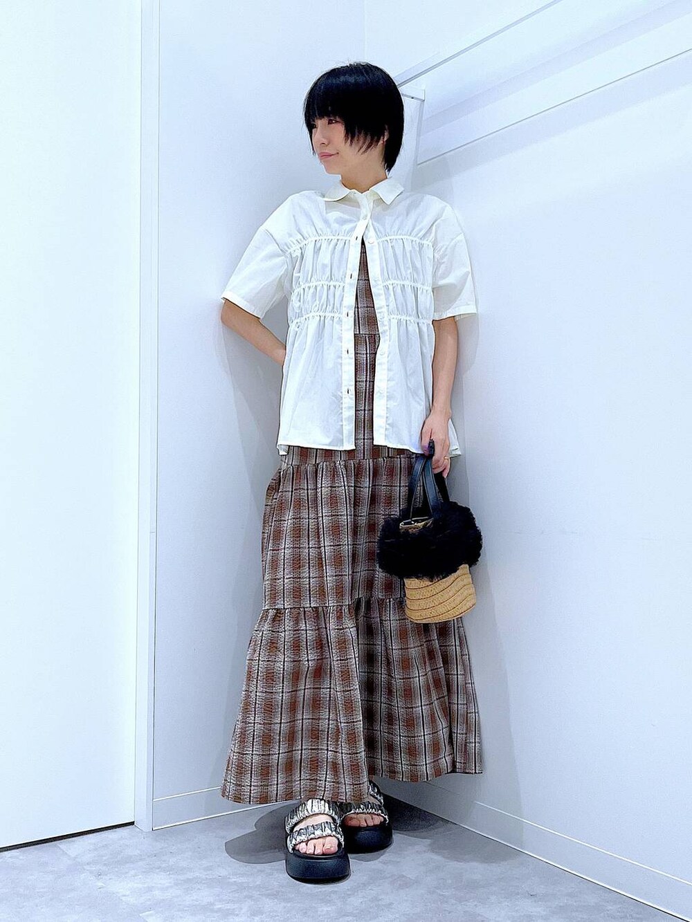 ベージュ系のショルダーバッグ、シルバー系のサンダル、ブラウン系のワンピースを着用したレディースの夏コーディネートの2枚目の写真