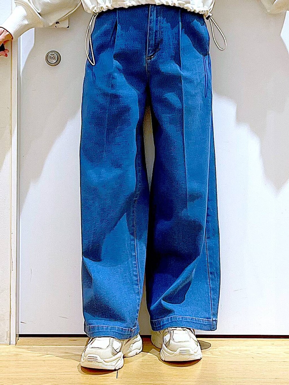 ホワイト系のスウェット、ブルー系のデニムパンツ、ベージュ系のスニーカーを着用したレディースの冬コーディネートの8枚目の写真