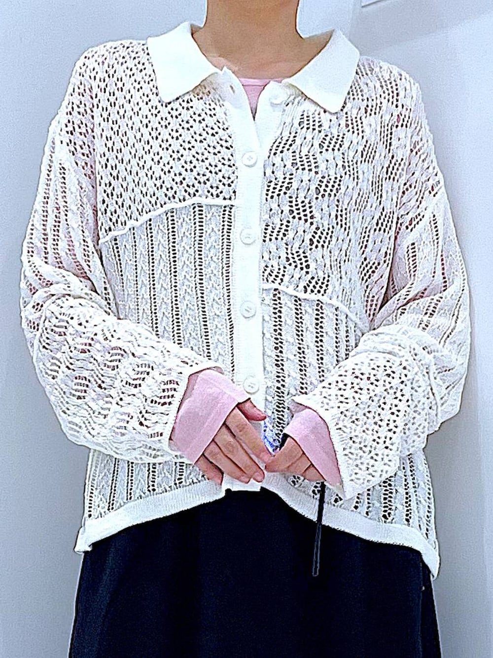 ブラック系のスカート、ピンク系のTシャツ/カットソー、ブラック系のブーツを着用したレディースの春コーディネートの7枚目の写真
