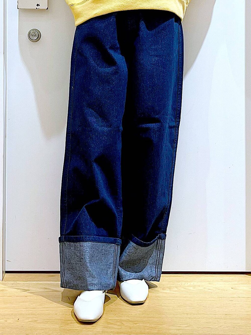 ホワイト系のパンプス、ブルー系のデニムパンツ、その他のトートバッグを着用したレディースの冬コーディネートの8枚目の写真