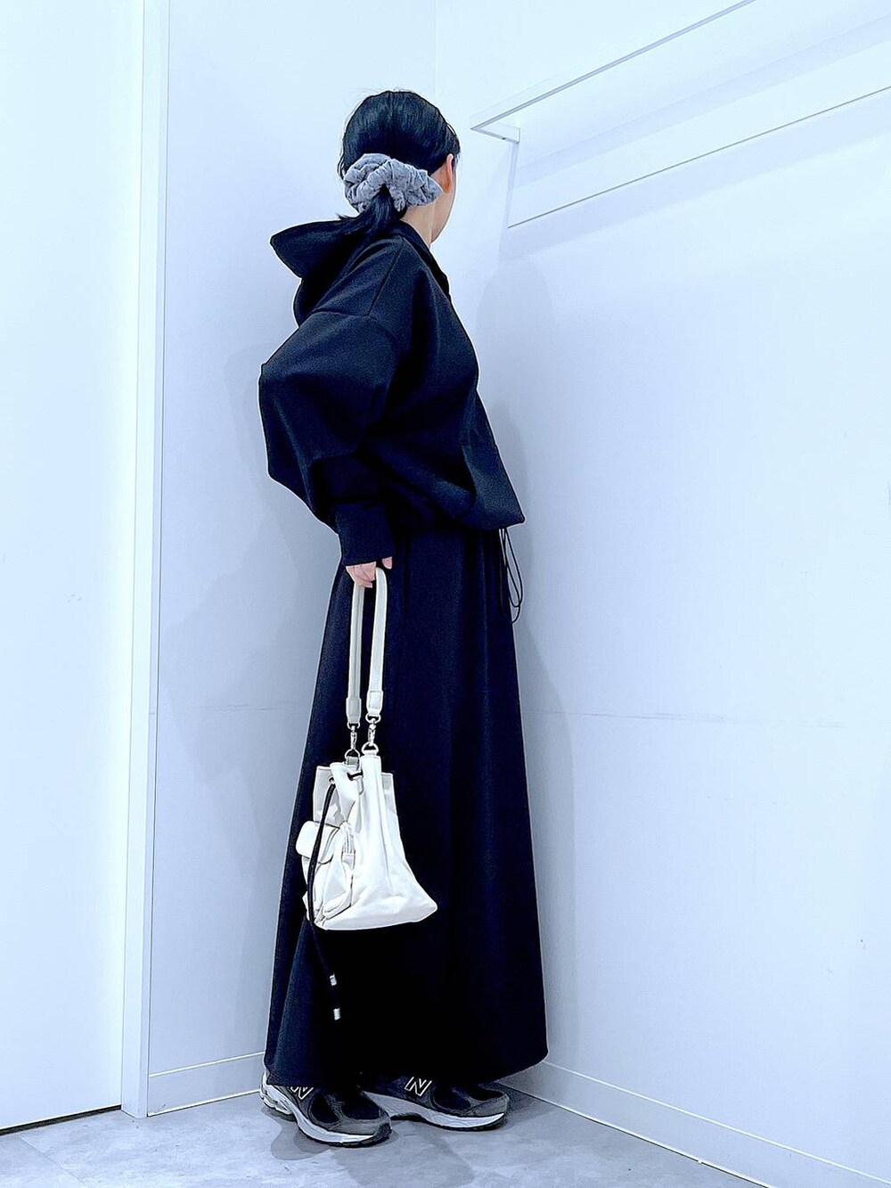 ベージュ系のショルダーバッグ、ブラック系のスウェット、ブラック系のスカートを着用したレディースの春コーディネートの4枚目の写真